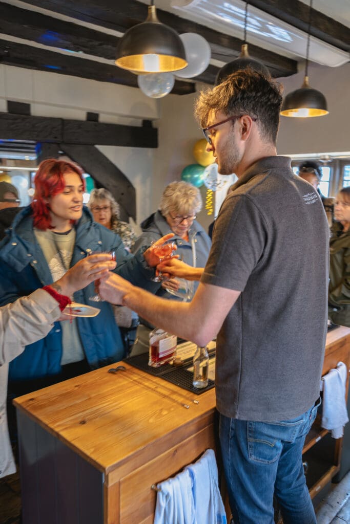 Sam serving cocktails to customers